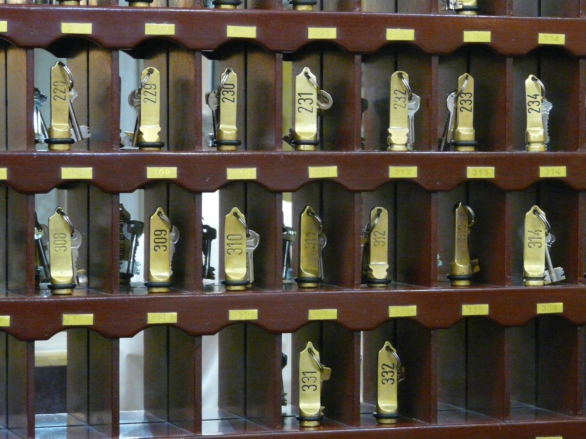 Hotel keys hanging in a numbered wooden key rack