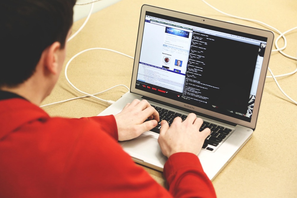 Programer koji radi za stolom s laptopom otvorenim na kodu—gdje predaje SSH ključeva često počinju