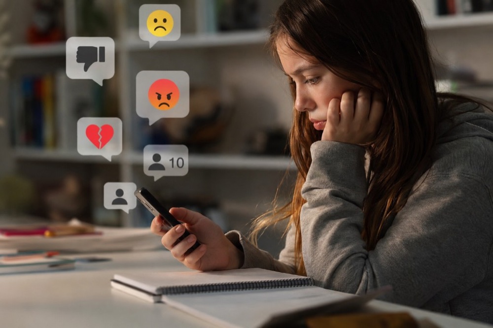 Teenager looking at a smartphone at home, illustrating debates over children's social media access and online safety policy